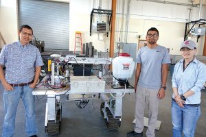 Researchers at Washington State University are collaborating with other universities to develop robotic weeding technology. Pictured, from left, with a research prototype of a weeding robot are Manoj Karkee, associate professor; Kapil Khanal, graduate student; and Xin Zhang, graduate student.