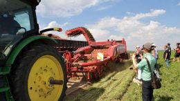 International Carrot Conference attendees watch a crew harvest carrots at Klaustermeyer Farms in Basin City, Wash.